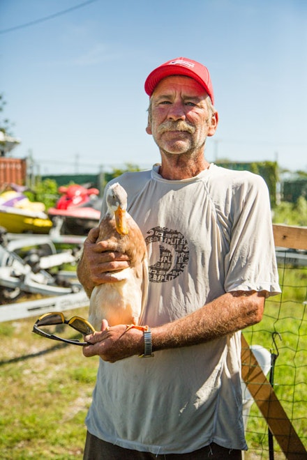 Parkway Marina mechanic Harry holds Daffy, a duck, one of several semi-aquatic animals he cares for year round.