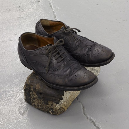 Yuji Agematsu, <em>untitled</em>, ca. 1993. Leather shoes on cobblestone. 7 1/2 × 11 × 9 1/4 inches. Photo: Thomas Müller.