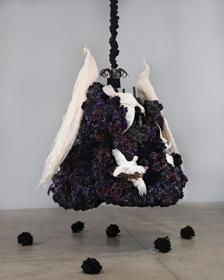 Petah Coyne, <em>Untitled #1375 (No Reason Except Love: Portrait of a Marriage)</em>, 2011-12. Specially-formulated wax, pigment, silk flowers, taxidermy, chandelier, candles, ribbons, black sand from pig iron casting, resin, paint, black pearl-headed hat pins, chicken-wire fencing, wire, cable, cable nuts, quick-link shackles, jaw-to-jaw swivel, silk/rayon velvet, 3/8” Grade 30 proof coil chain, Velcro, thread, plastic, 81 x 71 x 66.5 inches. © Petah Coyne. Courtesy Galerie Lelong & Co., New York.