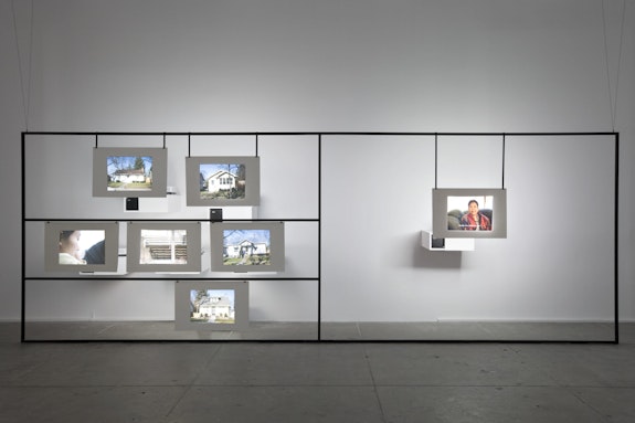 Amar Kanwar, <em>The Torn First Pages</em> (partial installation view). 2004-2008. Nineteen-channel standard-definition video (black and white and color, sound and silent; varying durations), nineteen sheets of paper, three metal frames, books, magazines, and artist books, dimensions variable. The Museum of Modern Art, New York. Acquired through the generosity of The Estate of Byron R. Meyer, Kiran Nadar, and The Contemporary Arts Council. © 2022 Amar Kanwar. Photo: Tom Powel Imaging.